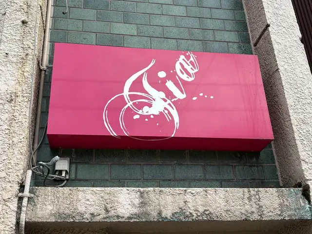 魚津駅前の鮮紅色に白い筆記体が走る看板