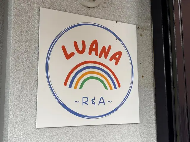 虹の線で囲んだ「LUANA」の丸看板