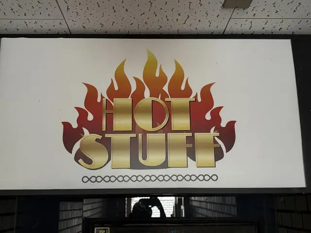 炎のロゴを掲げた「HOT STUFF」看板
