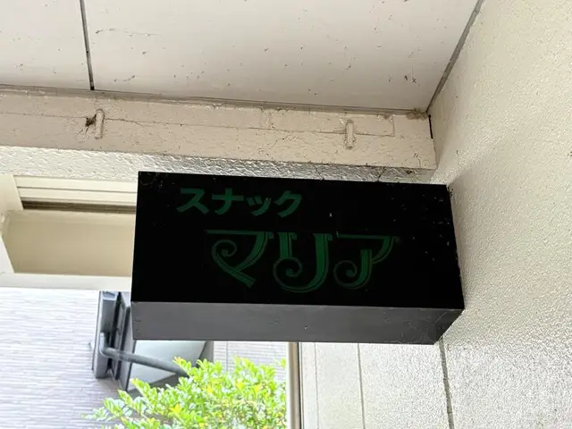 黒地に緑文字の「スナック マリア」