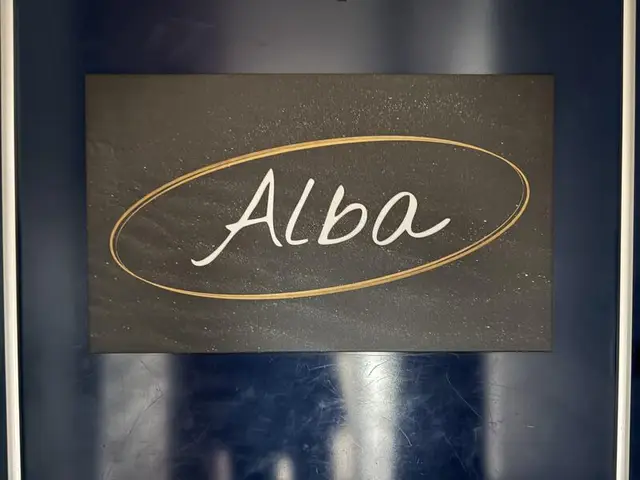 暗色の楕円に金縁の「Alba」