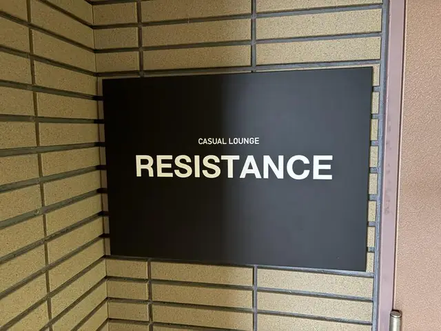 黒い角形に金字の「RESISTANCE」