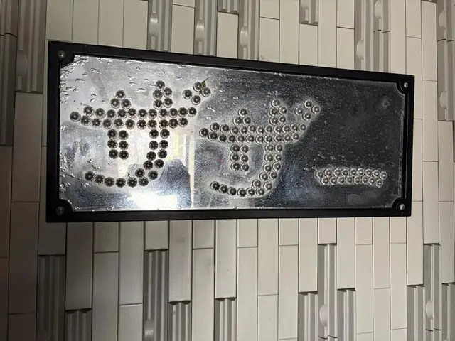 金属の点で文字をつくる魚津駅前の看板