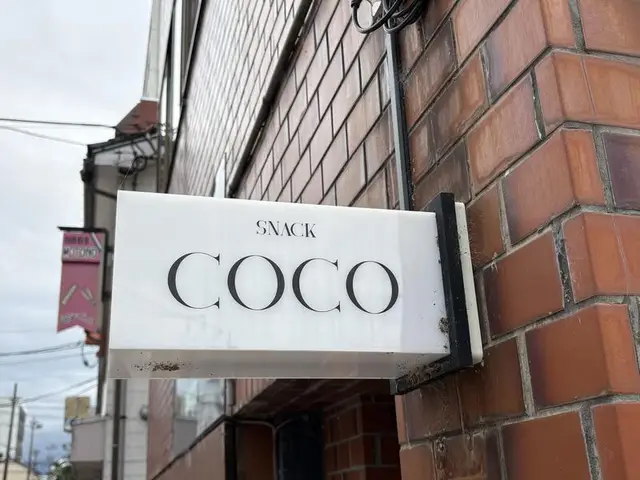 煉瓦壁から突き出す「SNACK COCO」