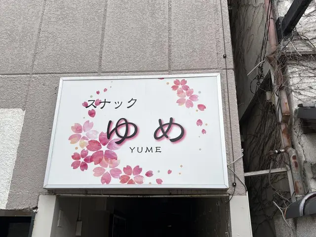 桜の意匠を散らした白い「スナック ゆめ」看板