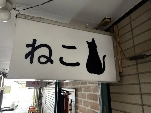 黒猫シルエットを添えた白い「ねこ」看板