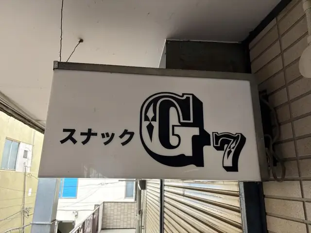 白地に大きな「G7」ロゴを置いたスナック看板