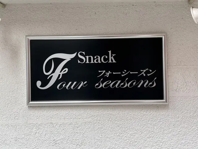 黒地に白い筆記体を置いた「Snack Four Seasons」看板