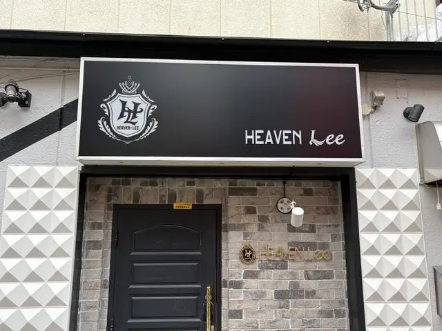黒いファサードに白文字を置いた「HEAVEN Lee」看板