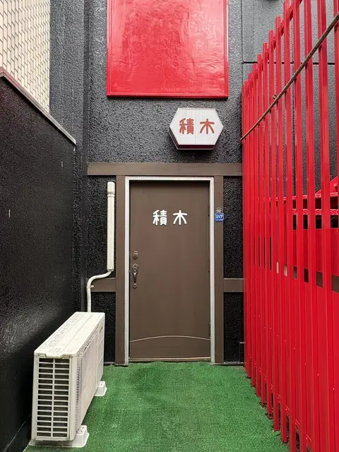 赤い格子の奥に続く「積木」の入口表示