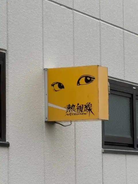 白壁に取り付けられた黄色い「熱視線」箱看板
