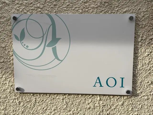 白いアクリル板に薄緑のロゴを入れた「AOI」表札看板