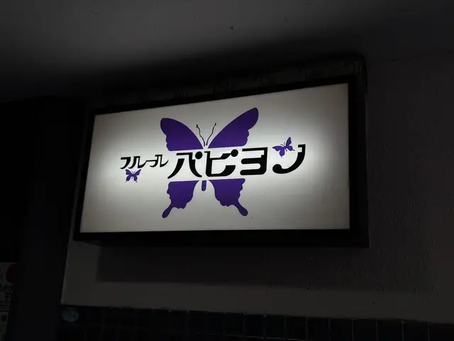 紫の蝶を大きく描いた「フルフル ハピョン」看板