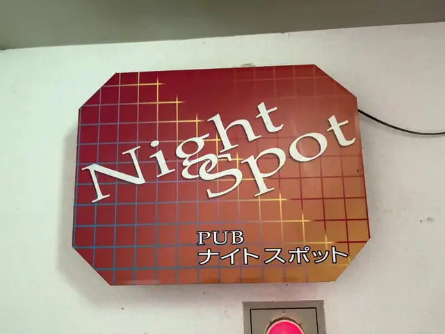 赤いチェック柄に白文字を載せた「PUB ナイトスポット」看板