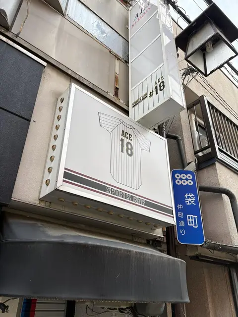 白い箱看板に翼の意匠を入れた「ACE 18」看板