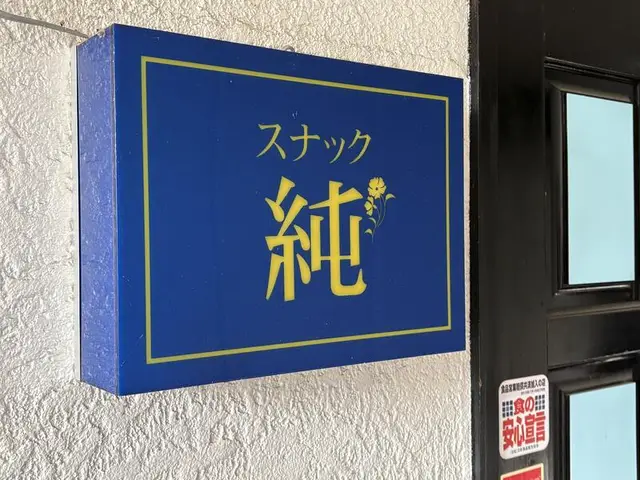 青地に金文字の「スナック 純」箱看板