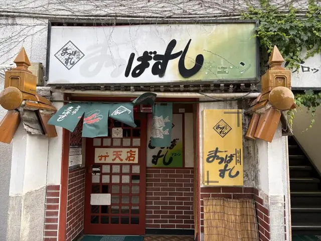 小さな店構えに重なる「まつばすし」看板群