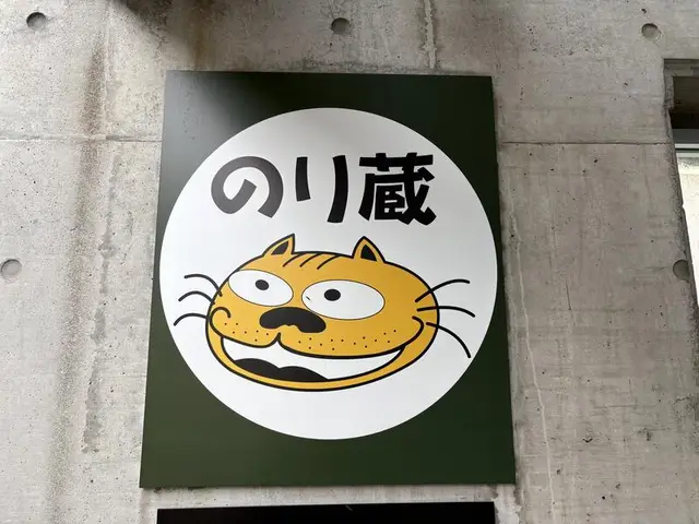 猫の顔が描かれた丸い「のり蔵」看板