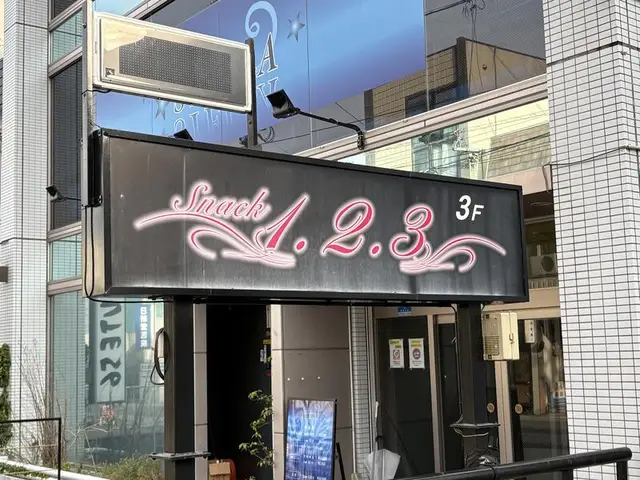 黒地にピンク文字の「Snack 1.2.3」3F 看板