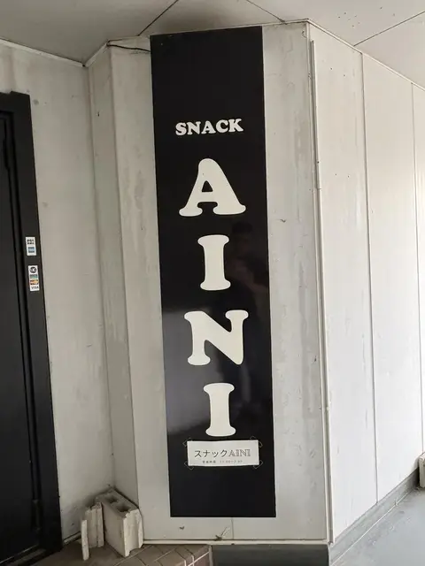 黒い縦型看板「SNACK AINI」