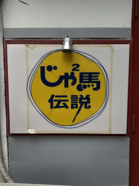 黄色い円ロゴの「じゃ馬伝説」入口看板