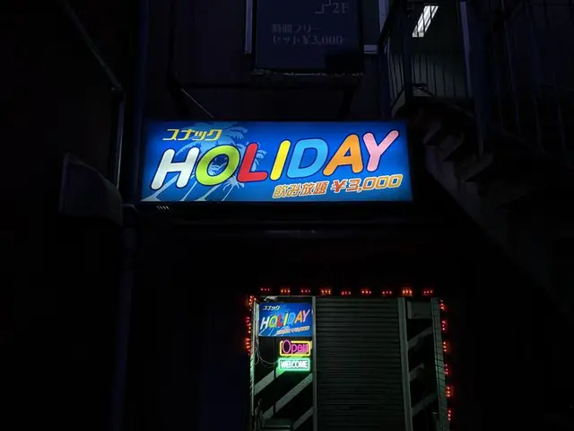 青く光る「スナック HOLIDAY」看板