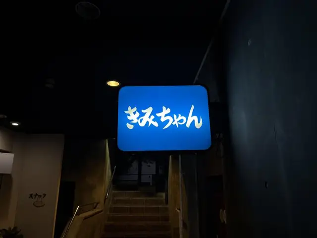 階段脇で青く光る「きみちゃん」看板