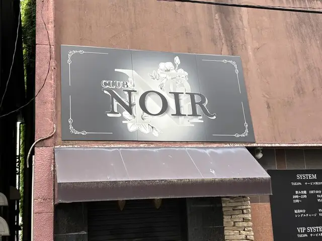 富山・桜木町の茶色い外壁に埋め込まれた「NOIR」のプレート